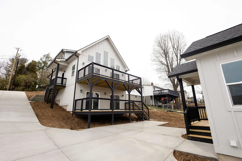 Newly built white residential homes with black decks and concrete driveways.