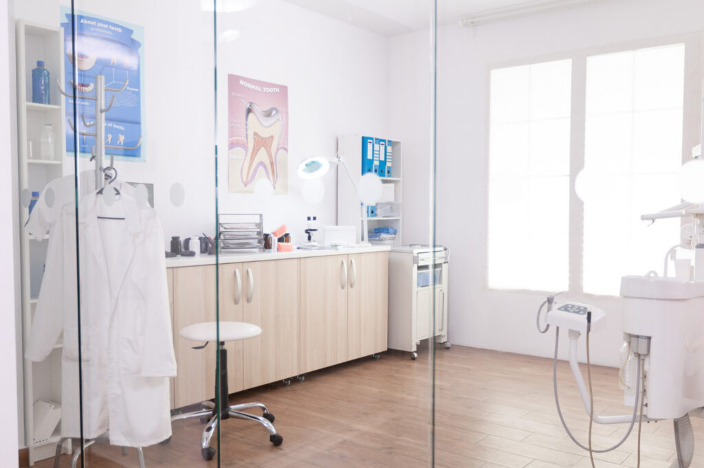 A new modern healthcare construction medical exam room with clean cabinets, and modern equipment in Asheville, NC.