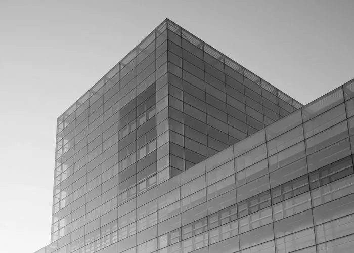 Black-and-white view of a modern glass-and-steel commercial building.