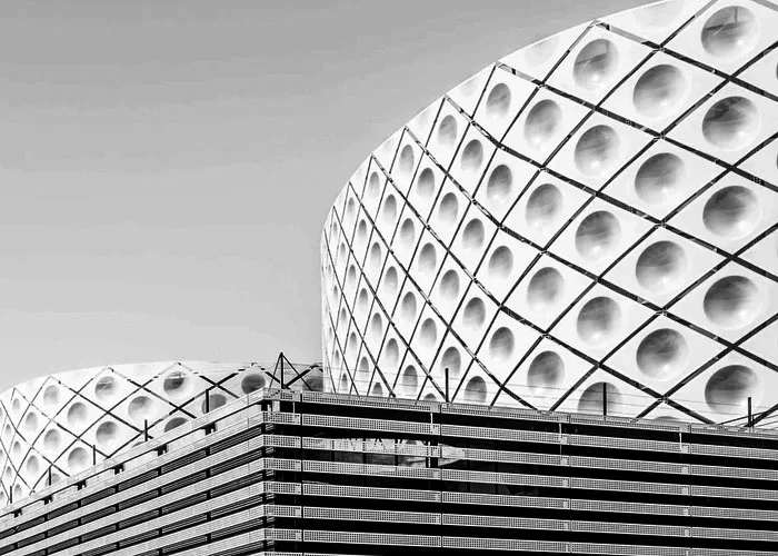 Black-and-white view of a contemporary commercial building with a geometric façade.