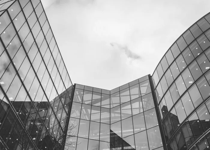 Black-and-white view of a modern commercial building with curved glass façades.