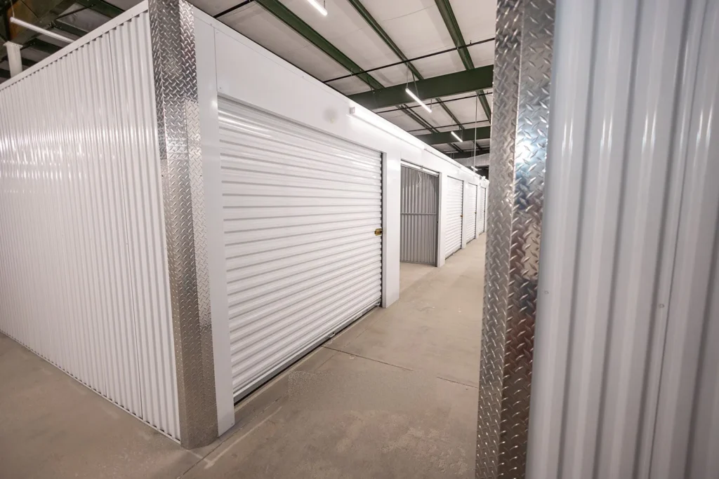 Indoor self-storage corridor with metal units and roll-up doors. SafeNest Storage in Asheville, NC.